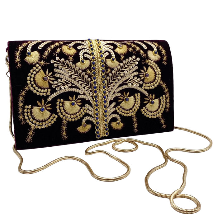 A purple velvet clutch with gold beadwork and embroidery, featuring a removable gold-toned chain shoulder strap.