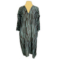 A dress with a geometric pattern in shades of green and black, displayed on a mannequin.