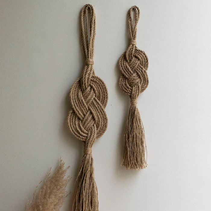 A handmade wall hanging decoration made with natural jute fiber rope, featuring a braided geometric pattern.