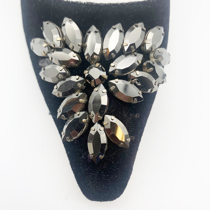 A pair of black velvet high-heeled shoes with dark grey rhinestone embellishments on the front, designed by Emma Hope.