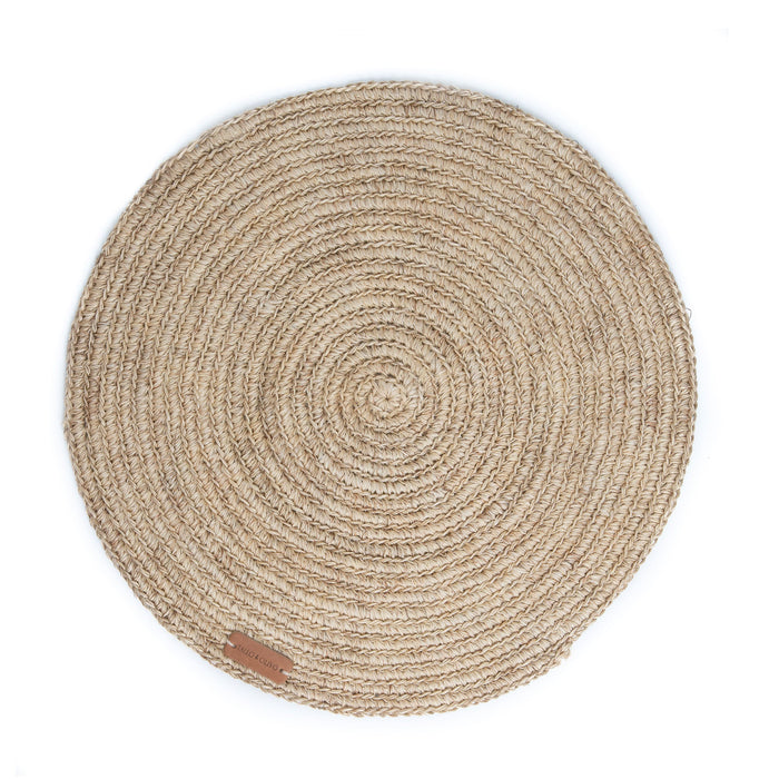 Round handwoven, natural fibre placemat made by Colombian artisans in beige tones.