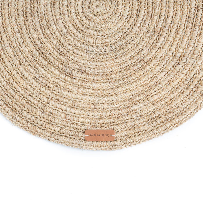 Round handwoven, natural fibre placemat made by Colombian artisans in beige tones.