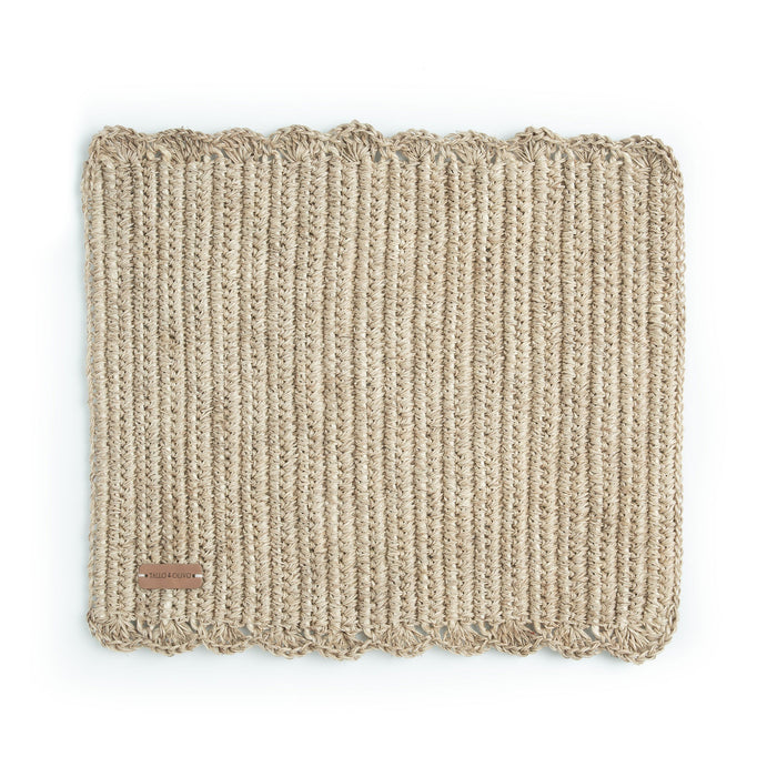 A rectangular, beige, handwoven placemat with a simple pattern.