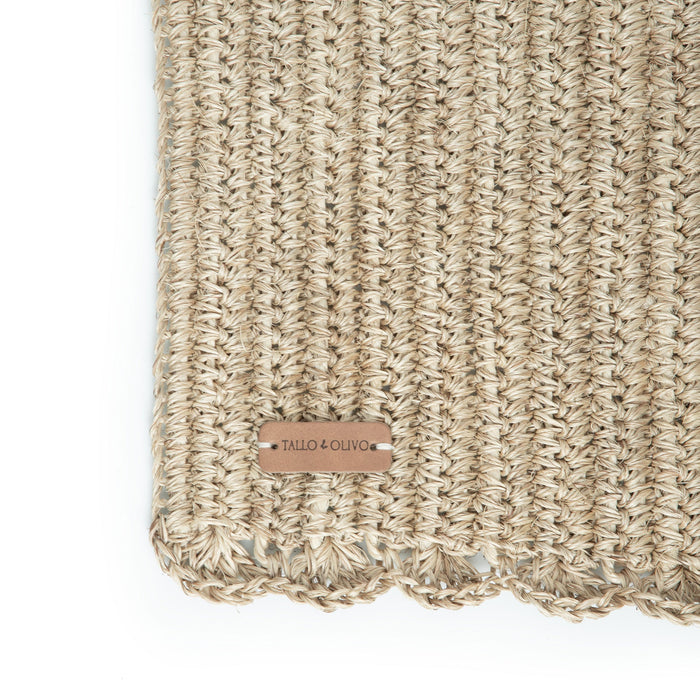 A rectangular, beige, handwoven placemat with a simple pattern.